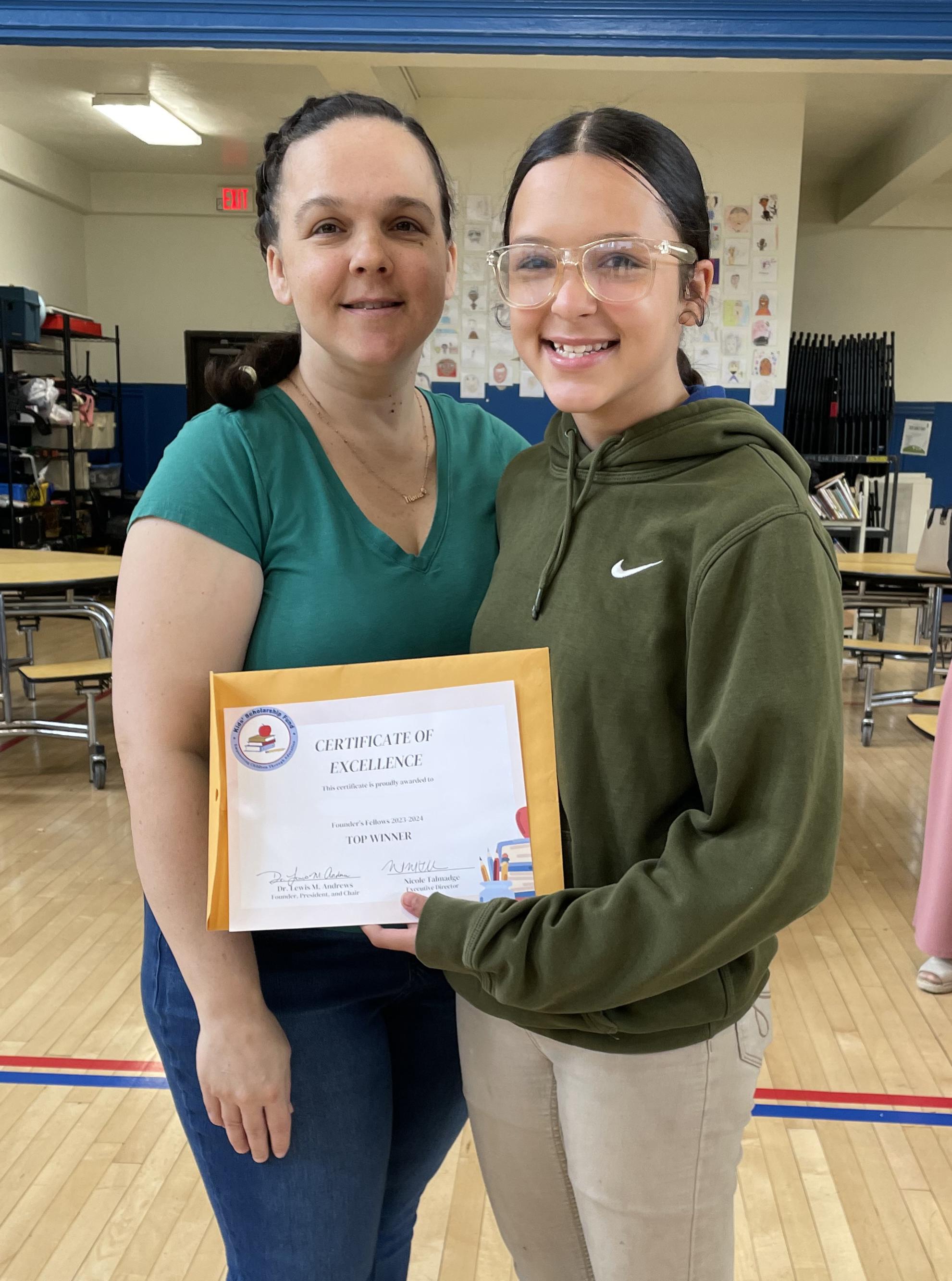 Juliana holding scholarship certificate